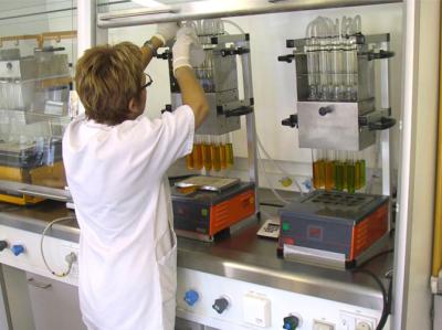 billedet forestiller en laborant i et laboratorium, der håndterer spildevandsprøver