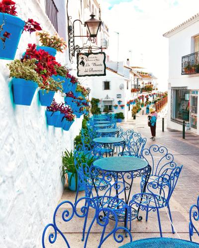 En række blå cafeborde langs vejen i en sydeuropæisk by